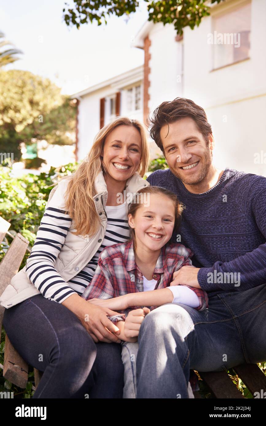 Familienzeit zu Hause. Ein Porträt einer glücklichen Familie, die vor ihrem Haus posiert. Stockfoto