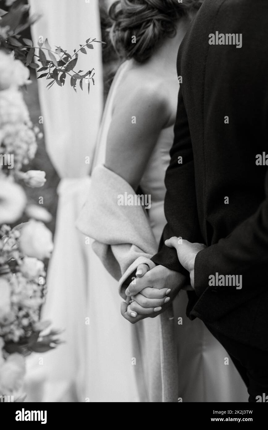 Braut und Bräutigam halten sanft Händchen Stockfoto