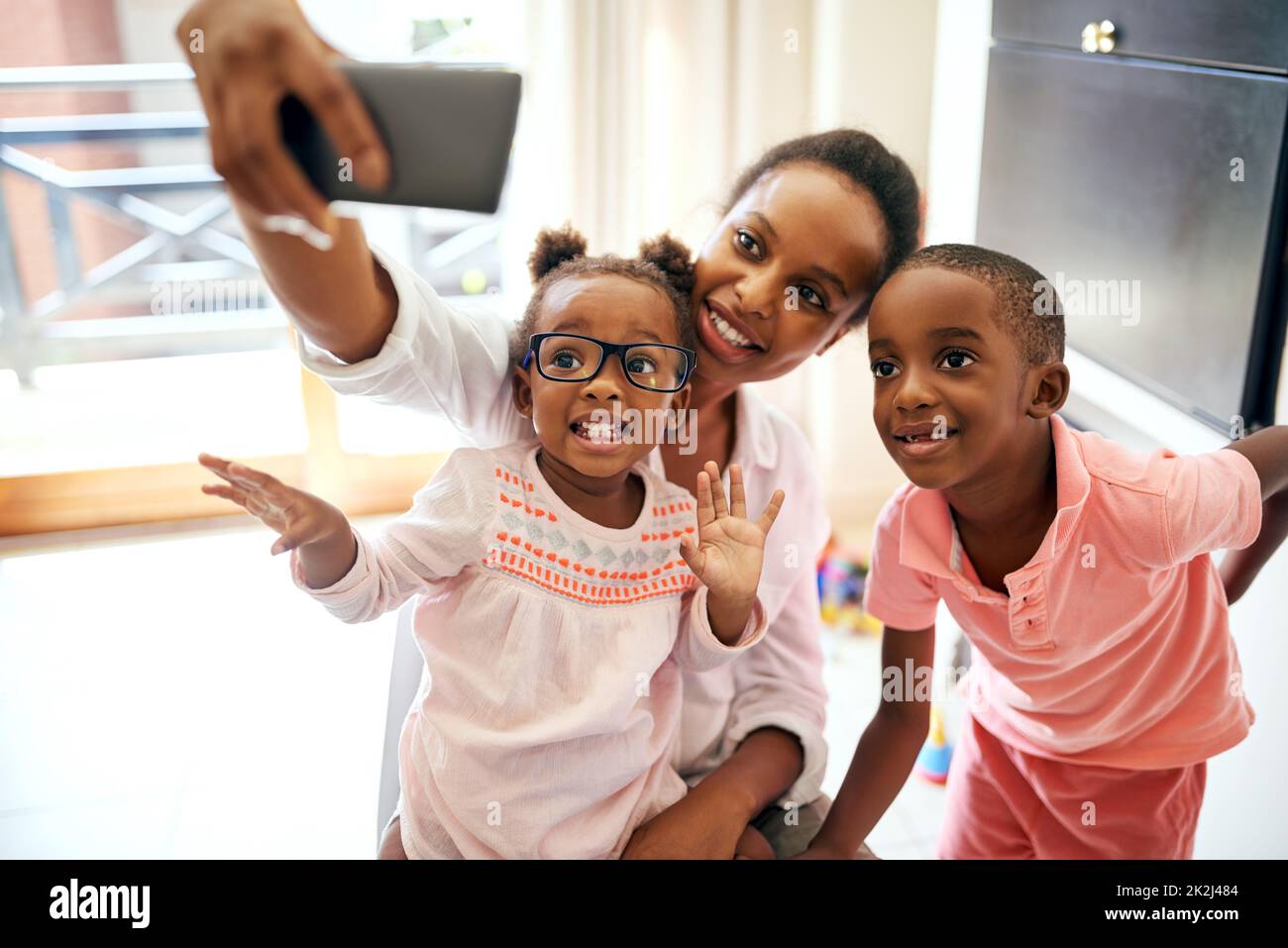 Glückliche Momente festhalten. Eine kurze Aufnahme einer liebevollen jungen Familie, die zu Hause Selfies macht. Stockfoto