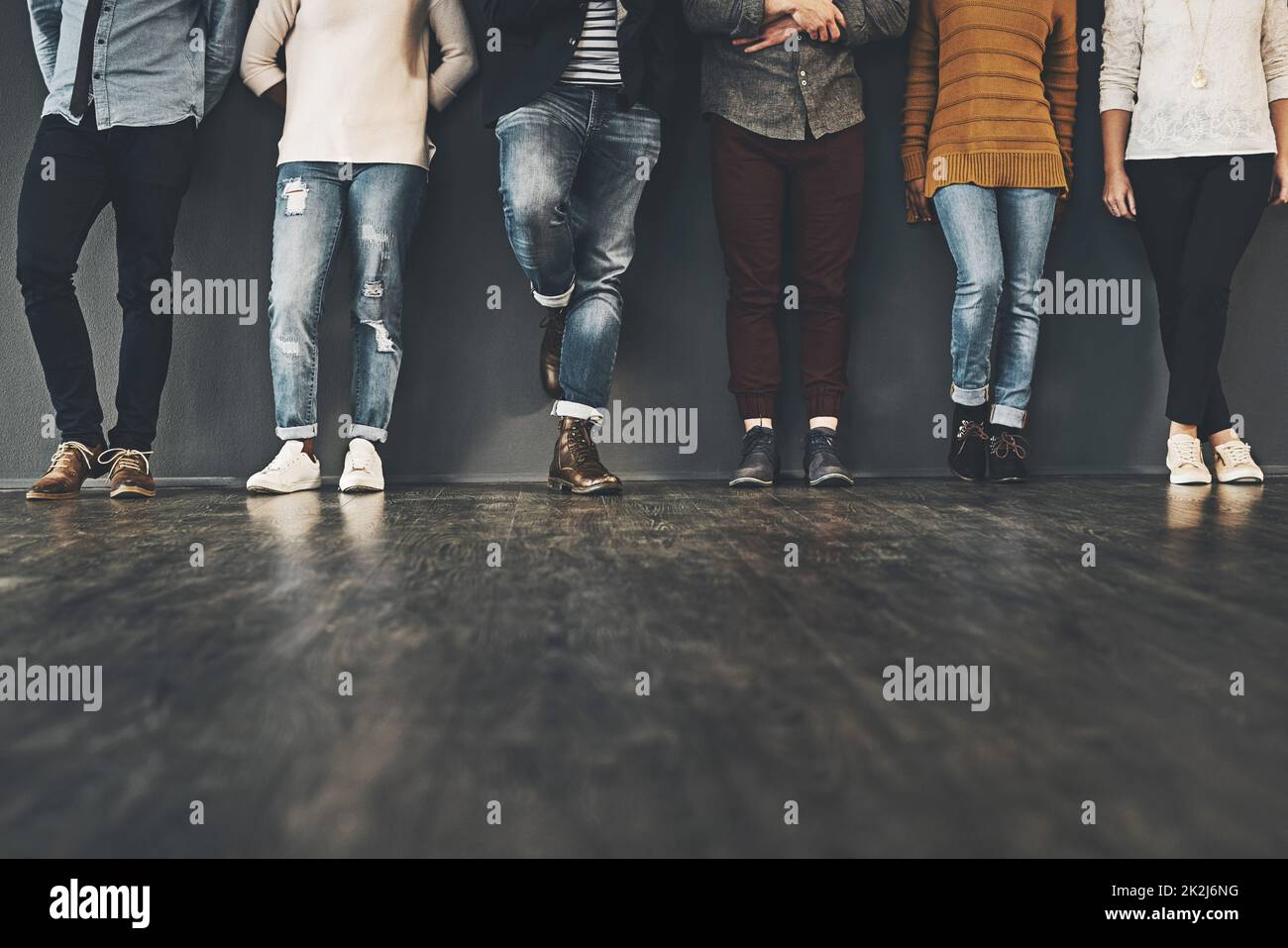 Seien Sie trendy in Ihrer Haltung. Studioaufnahme einer Gruppe von nicht erkennbaren Menschen, die vor einem grauen Hintergrund stehen. Stockfoto