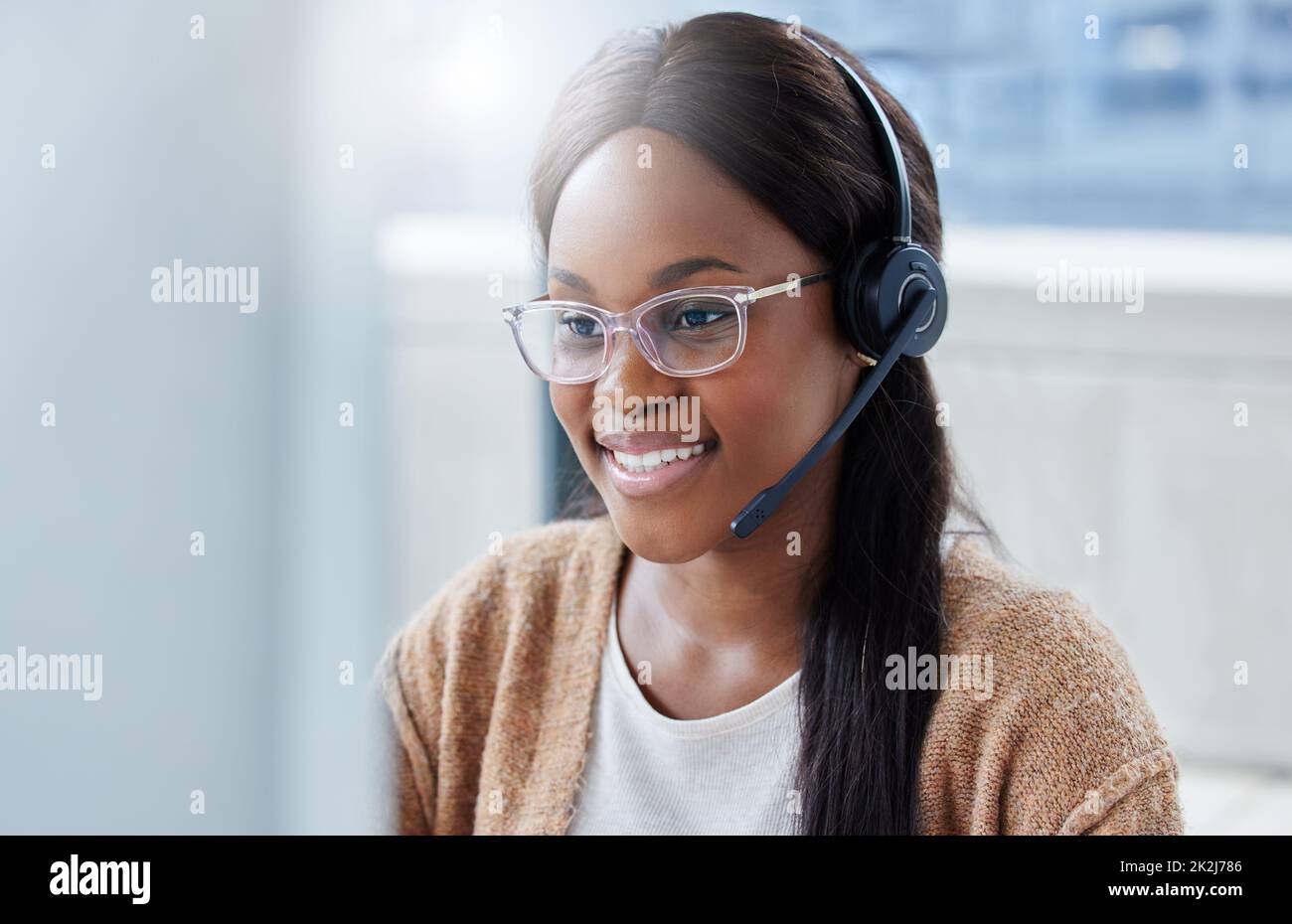 Hallo, wie können wir Ihnen heute helfen? Aufnahme einer Geschäftsfrau, die in einem Callcenter-Büro an ihrem Schreibtisch sitzt. Stockfoto