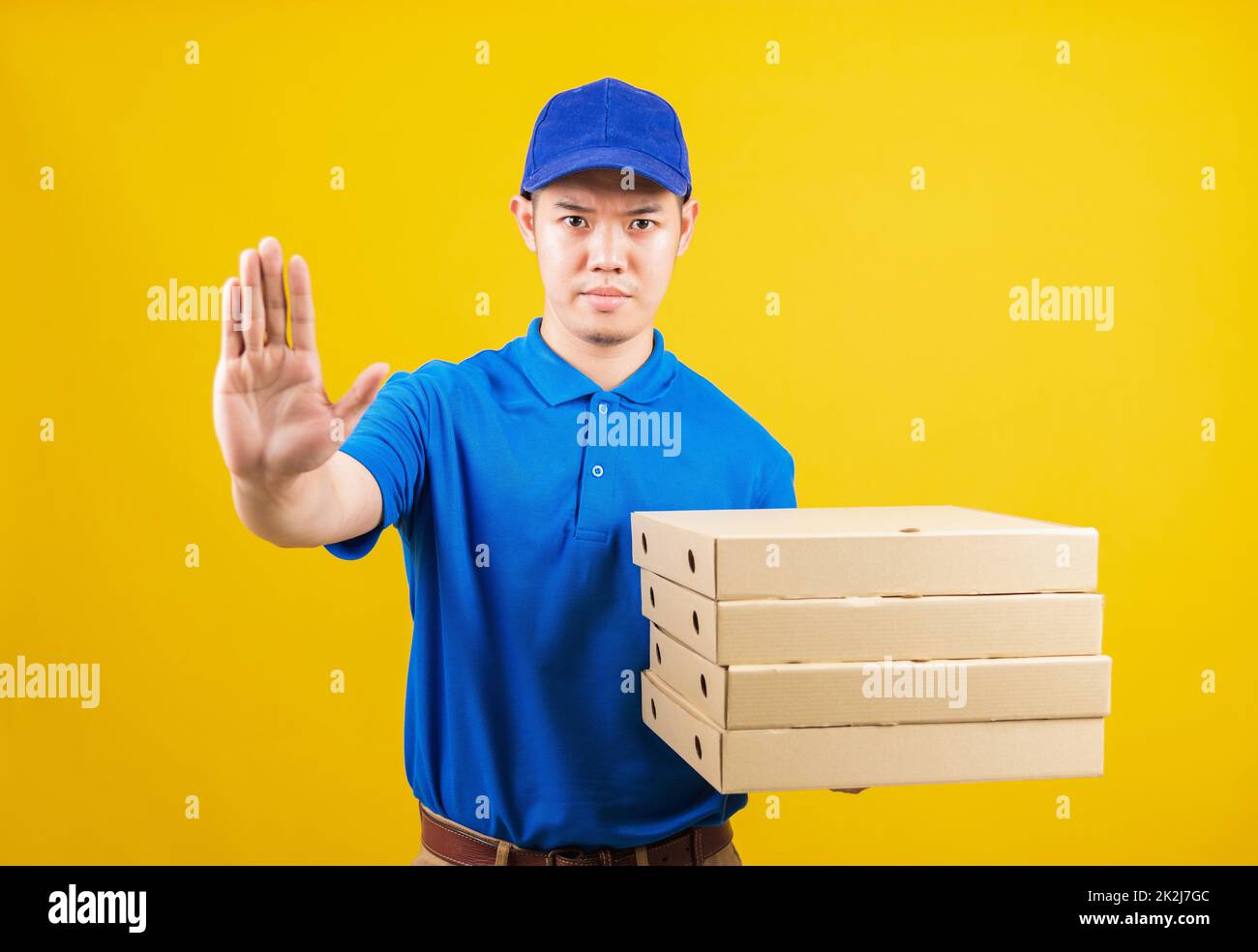 Lieferservice Mann mit blauem T-Shirt und Kappe Uniform halten Papierkiste italienische Pizzapackung und zeigen Hand-Stopp-Zeichen-Geste Stockfoto