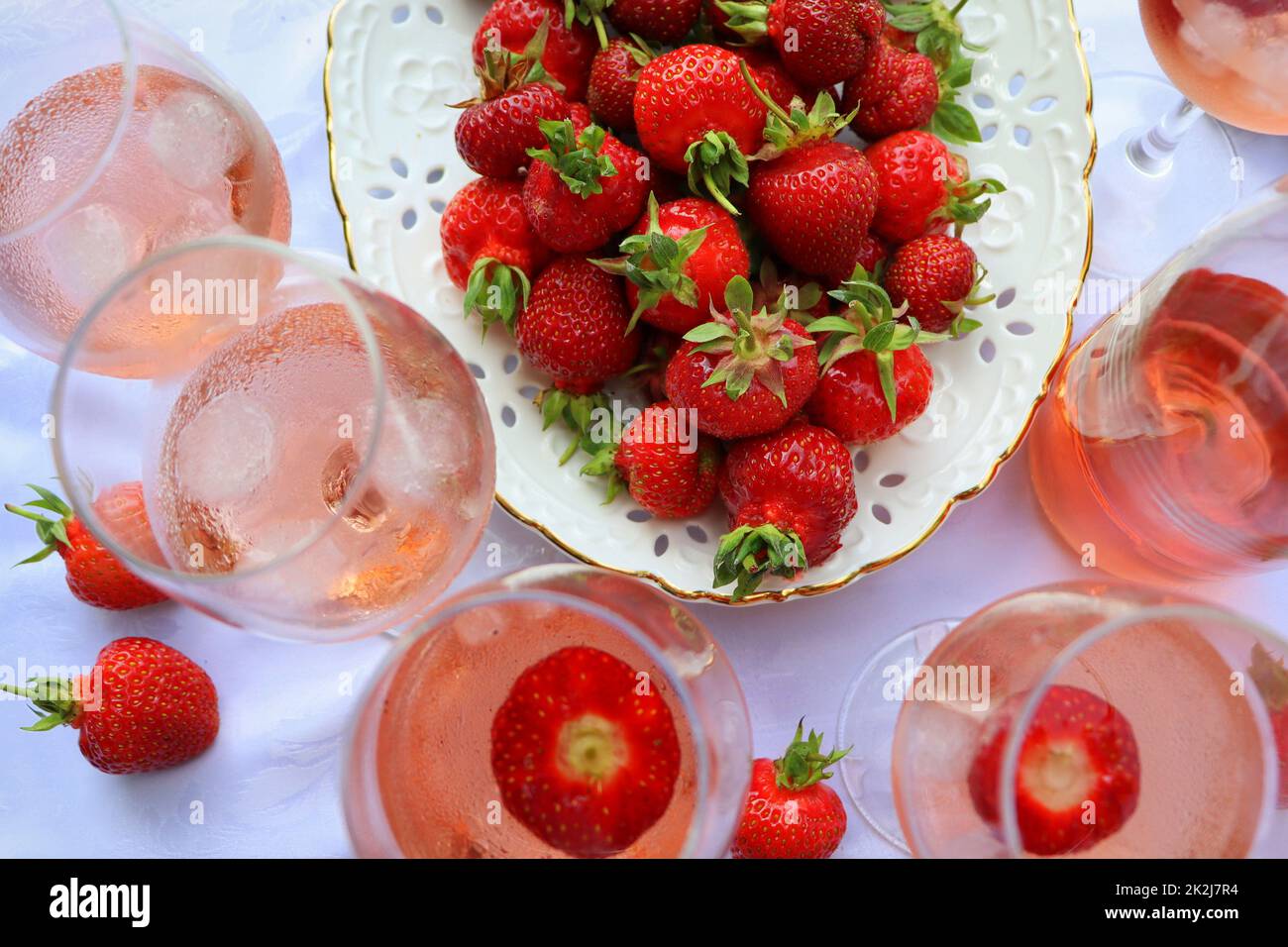 Kreative Komposition mit Rosenwein und leckeren Erdbeeren auf weißem Hintergrund, Draufsicht Stockfoto