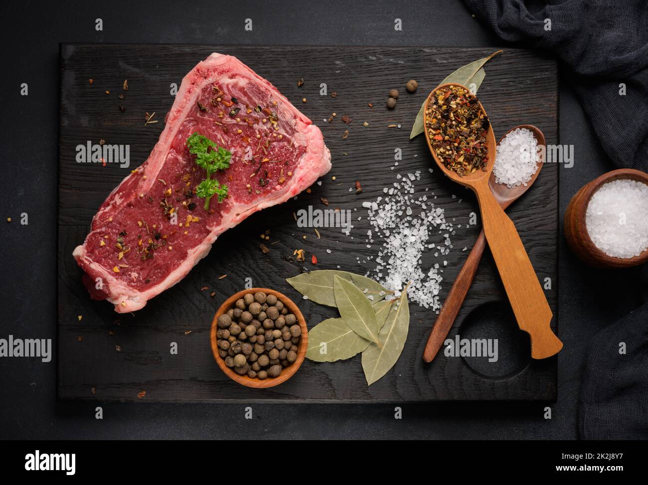 Rohes Stück Rindfleisch, Striploin-Steak auf schwarzem Hintergrund, Draufsicht. Marmoriertes Stück Fleisch New York Stockfoto