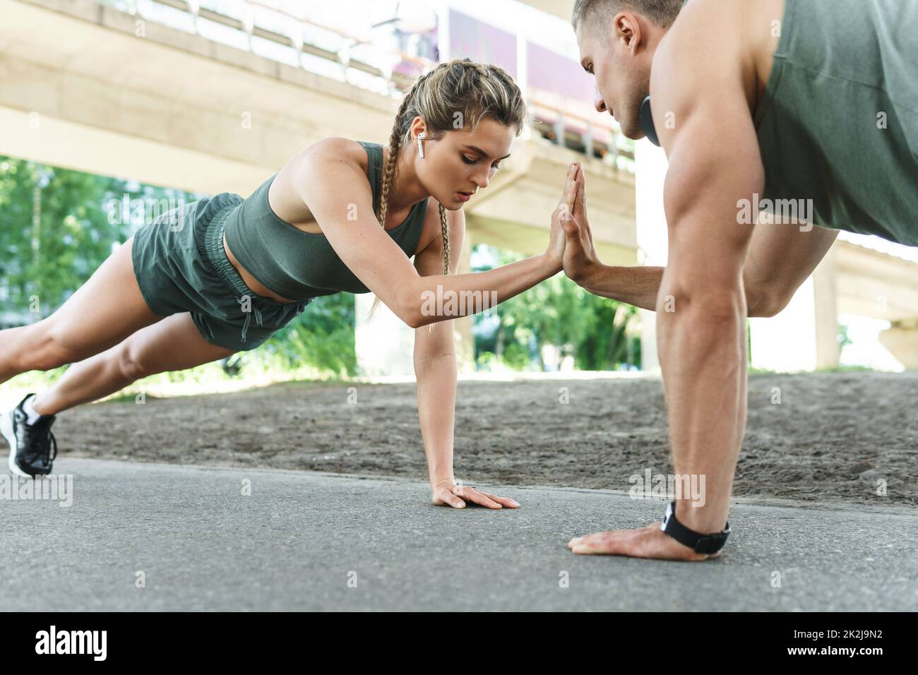 Sportliches Paar und Fitnesstraining im Freien. Mann und Frau tun Liegestütze Übung. Stockfoto