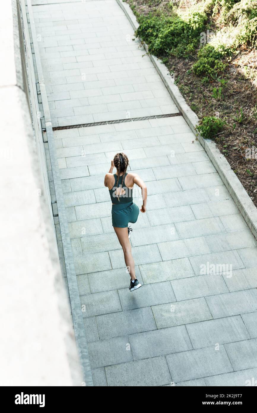 Die athletische Frau läuft während ihres Street-Workouts schnell Stockfoto