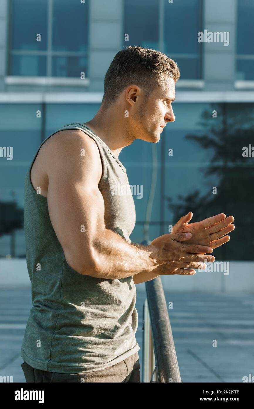 Muskulöser Mann, der sich vor seinem Fitness-Workout im Freien aufwärmt Stockfoto