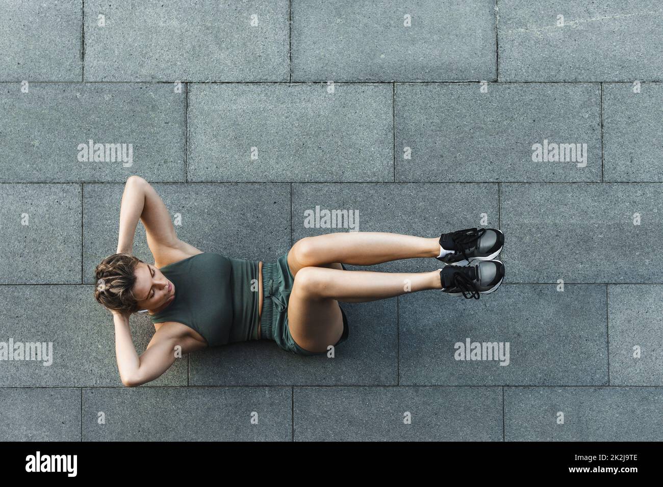 Athletische Frau tun Bauch knirscht Übung auf Betonboden Stockfoto