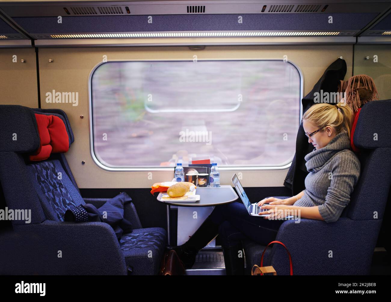 Unterhaltung für die lange Fahrt. Kurzer Screenshot einer attraktiven jungen Frau, die mit dem Zug unterwegs ist. Stockfoto