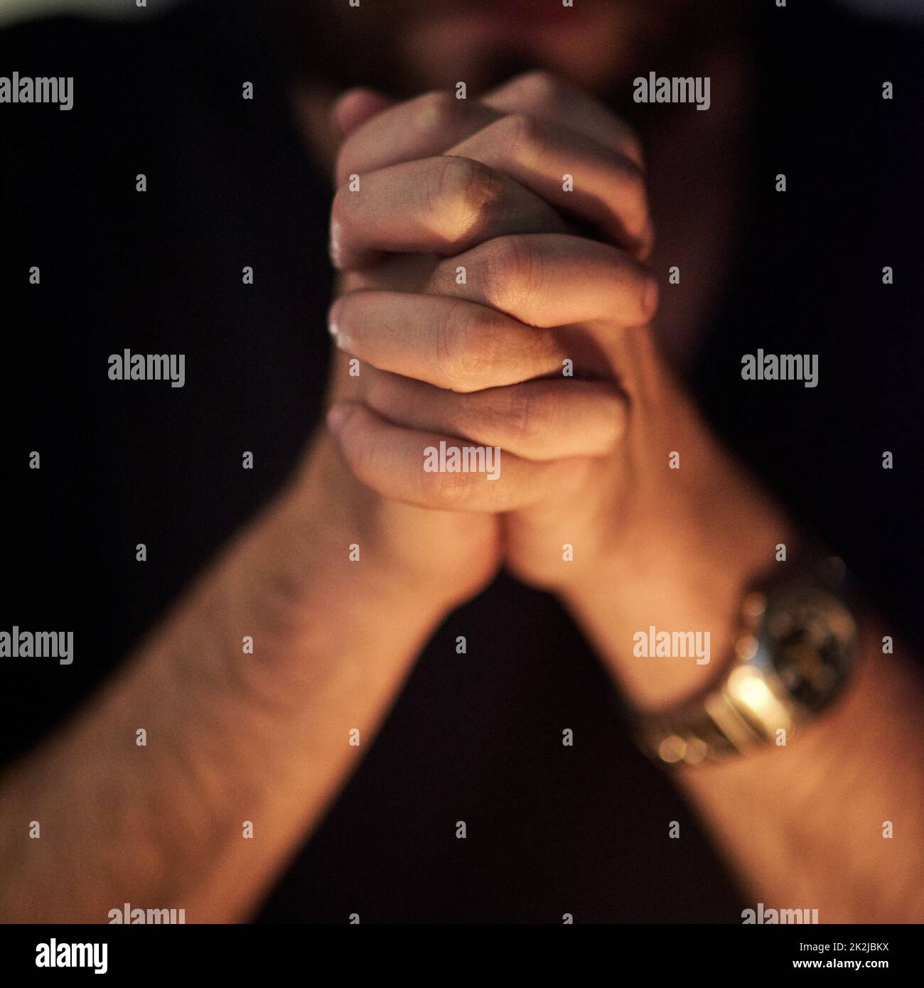 Betet um Vergebung. Nahaufnahme eines Mannes, dessen Hände im Gebet zusammengeklemmt sind. Stockfoto
