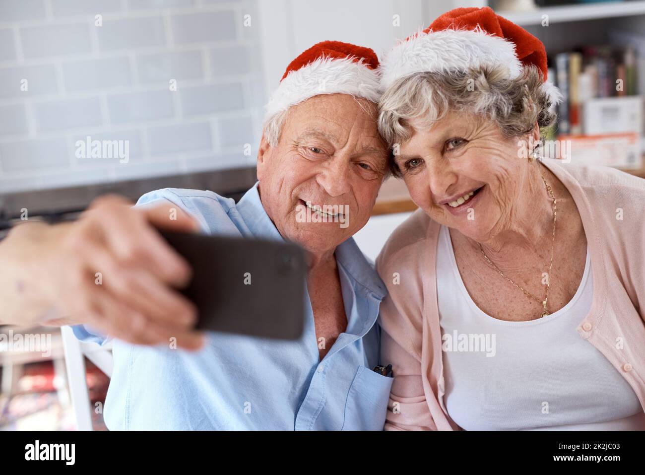 Nehmen Sie das Bild bereits auf. Aufnahme eines älteren Paares, das zu Hause ein festliches Selfie gemacht hat. Stockfoto