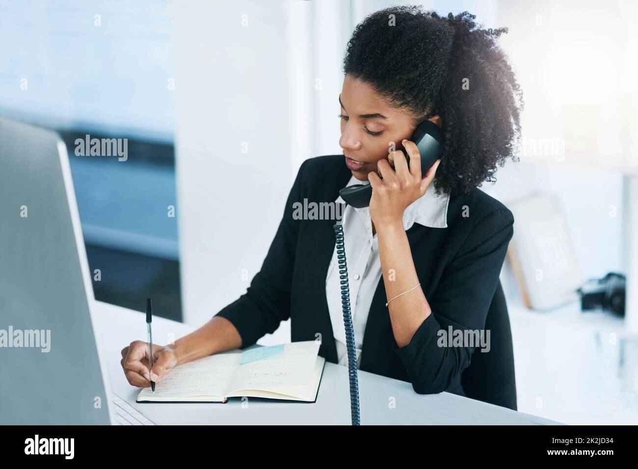 Ich rufe an, um unser Treffen für morgen zu bestätigen Aufnahme einer jungen Geschäftsfrau, die in einem Büro am Telefon spricht. Stockfoto