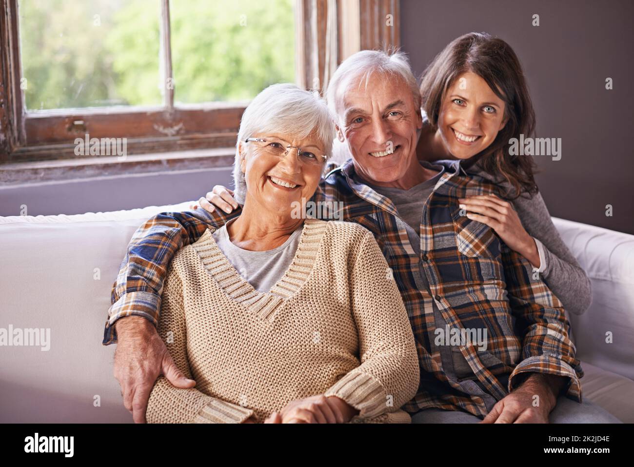 Meine Mutter und mein Vater meinen mir die Welt. Ein beschnittenes Porträt eines glücklichen älteren Ehepaares und ihrer erwachsenen Tochter zu Hause. Stockfoto