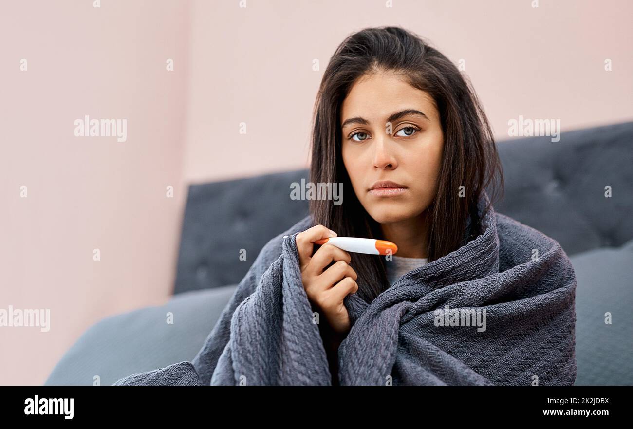 Sein Beamter, ich habe die Grippe bekommen. Aufnahme einer jungen Frau, die sich während der Genesung von einer Krankheit im Bett zu Hause temperiert. Stockfoto