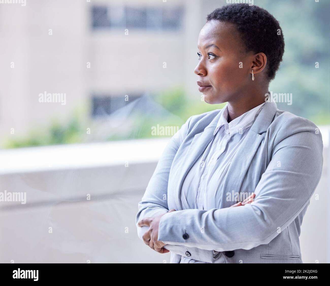 Die Aussicht genießen. Aufnahme einer jungen Geschäftsfrau, die aus dem Fenster schaut. Stockfoto