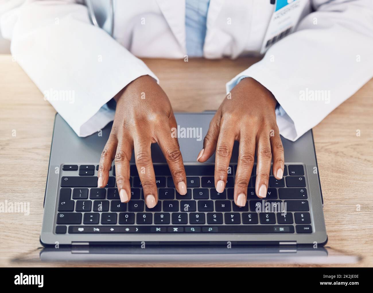 Hände, Frau und Arzt mit Laptop arbeiten an einem Schreibtisch in einem Krankenhausbüro. Medizinischer Experte mit drahtloser Technologie zur Diagnose oder Erforschung von Krankheiten Stockfoto