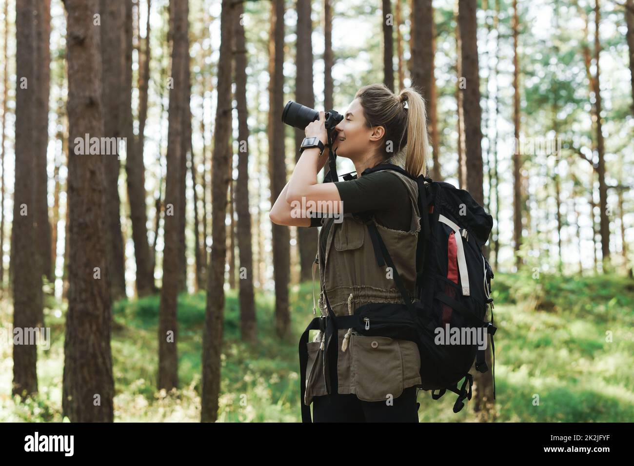Wanderer fotografiert mit einer modernen spiegellosen Kamera im grünen Wald Stockfoto