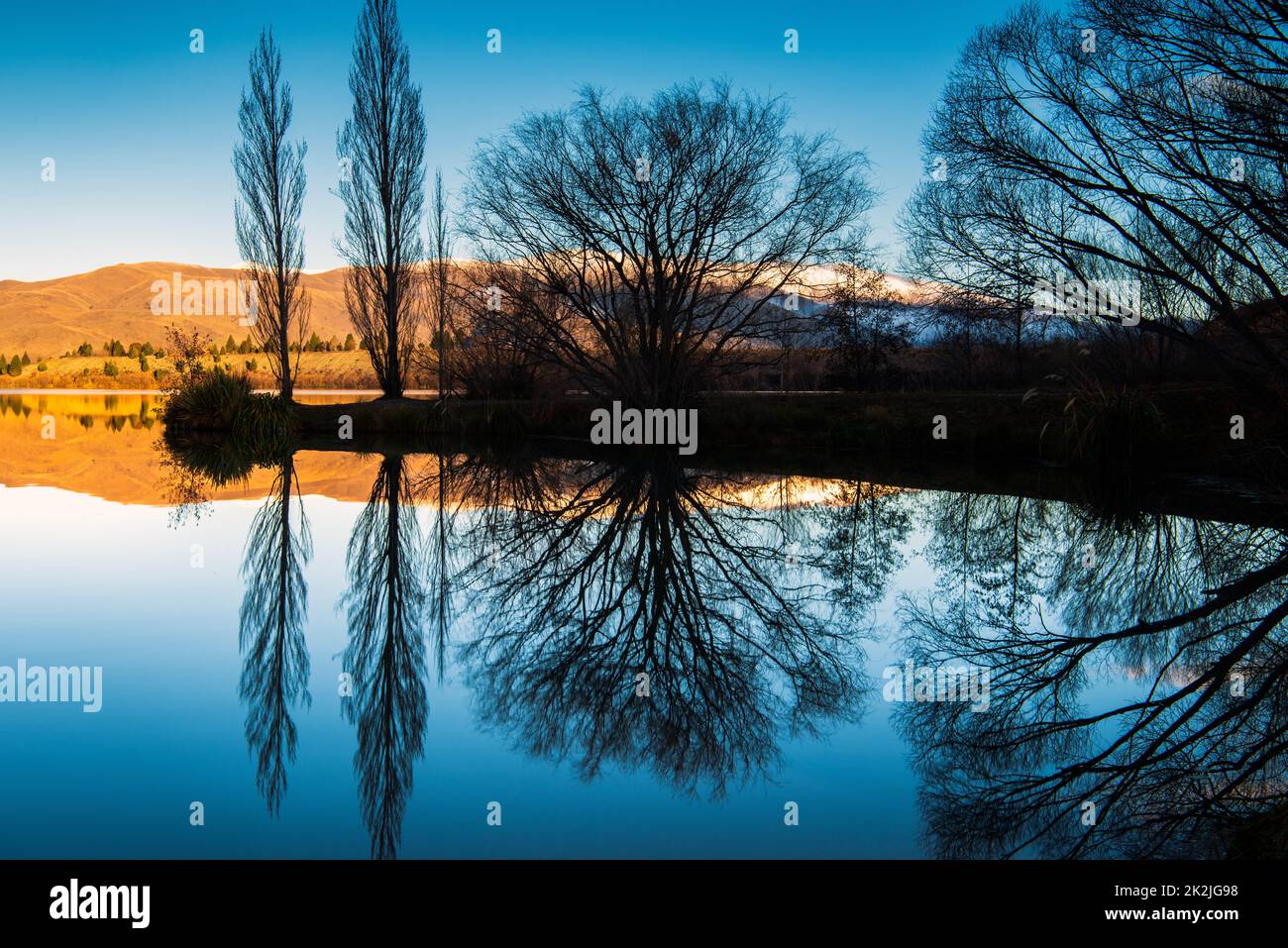 An einem Winter wird Licht gesehen, das von einem stillen Ruataniwha-See in Twizel reflektiert wird. Südinsel, Neuseeland. Stockfoto