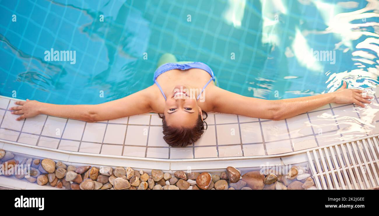 Das Leben ist einfach nur Wasser hinzufügen. Aufnahme einer jungen Frau, die sich in einem Spa im Pool entspannen kann. Stockfoto