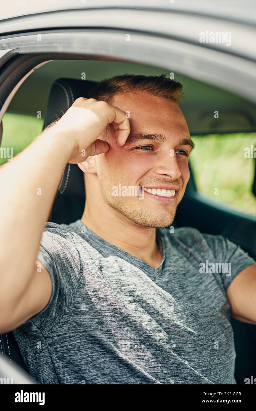 Er genießt die Freiheit, unterwegs zu sein. Aufnahme eines jungen Mannes, der ein Auto fährt. Stockfoto