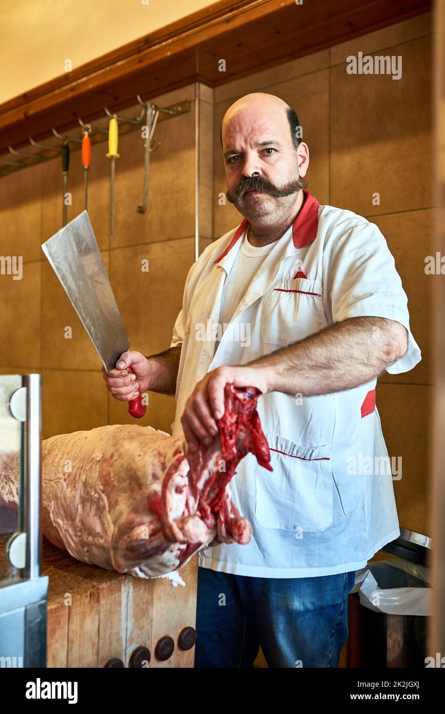 Kommt zu meiner Metzgerei, wenn Ihr hochwertiges Fleisch wollt. Schuss eines Metzgers in seinem Laden. Stockfoto