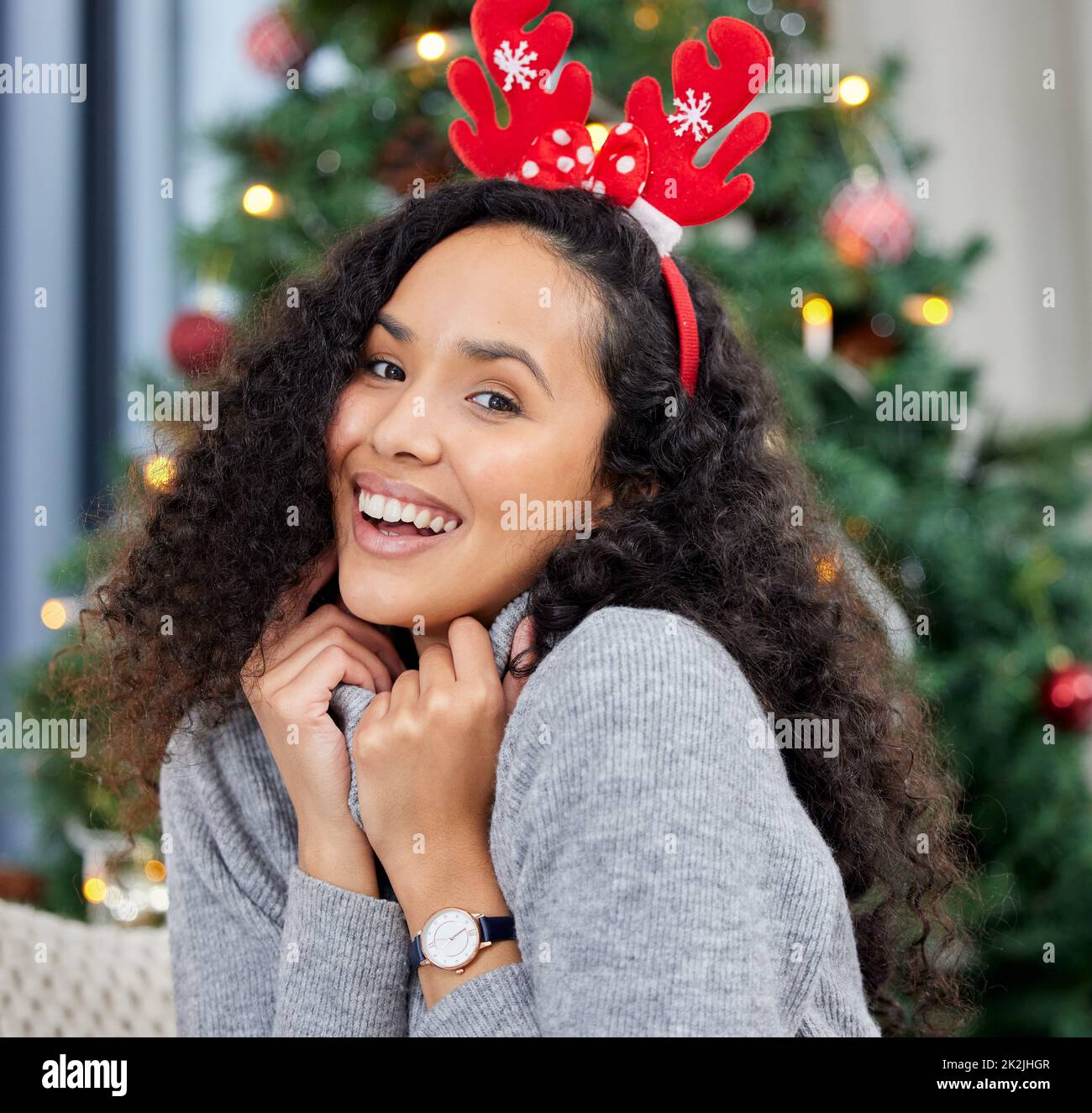 Bequem zu Weihnachten. Aufnahme einer jungen Frau, die zu Hause Weihnachten feiert. Stockfoto