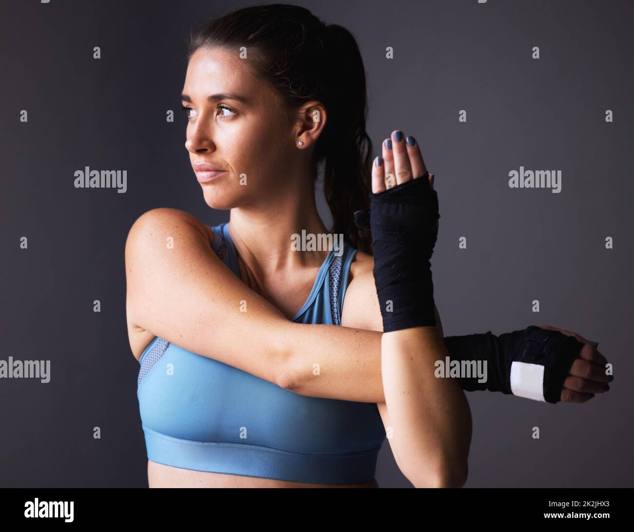 Es ist alles im Kopf. Aufnahme einer jungen Frau, die ihre Arme vor einem grauen Hintergrund streckt. Stockfoto