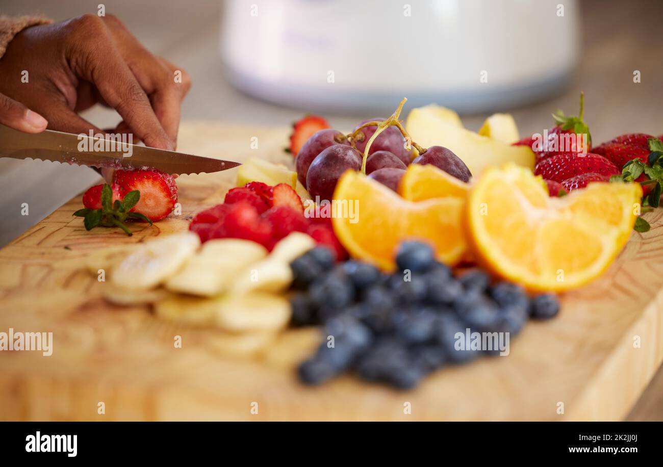 Vorbereitung einige gesunde Güte zu Snack auf. Nahaufnahme einer unkenntlichen Frau, die zu Hause frisches Obst schneidet. Stockfoto