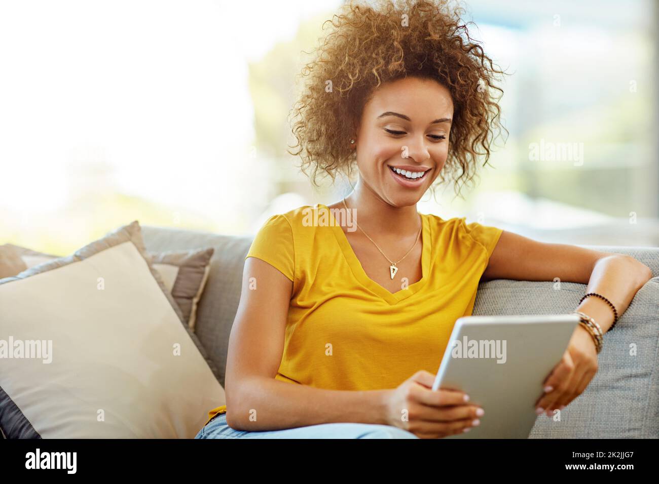 Schnurlose Freiheit das ganze Wochenende lang. Aufnahme einer jungen Frau mit einem digitalen Tablet an einem entspannten Tag zu Hause. Stockfoto