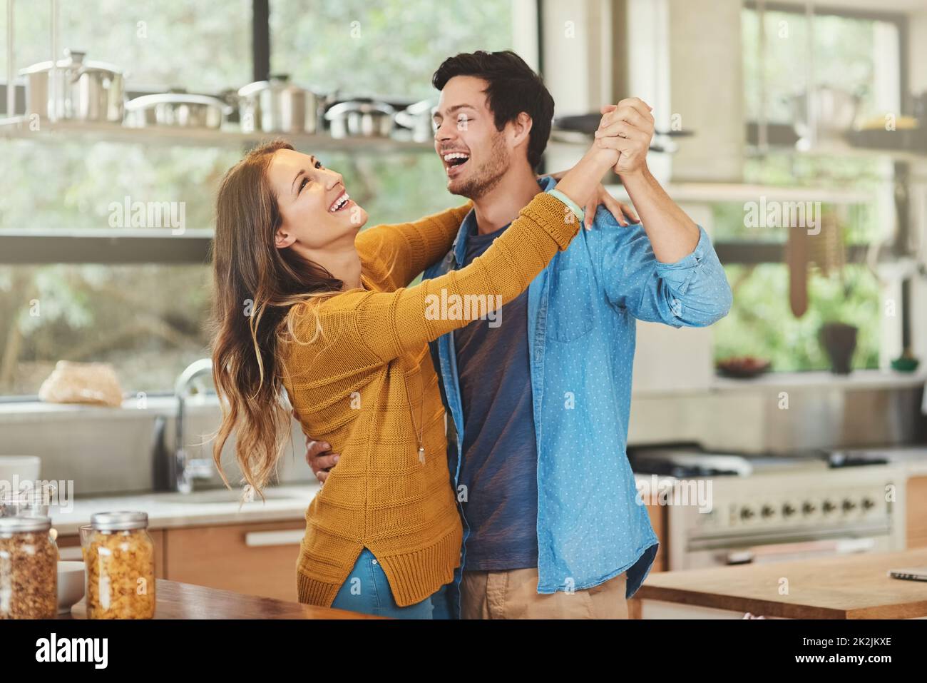 Lasst uns den Morgen wegtanzen. Aufnahme eines liebevollen jungen Paares, das in seiner Küche tanzt. Stockfoto