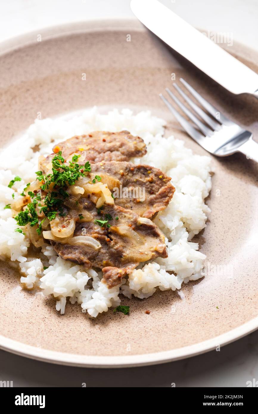 Schweinefleisch mit Zwiebelsauce und Reis Stockfoto