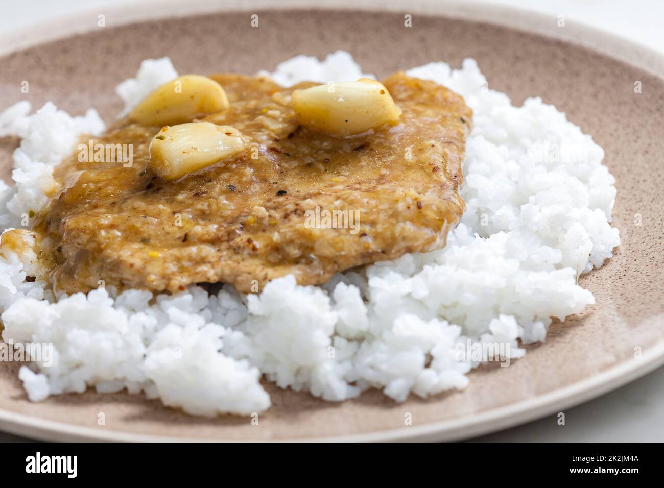 Schweineschnitzel mit Knoblauch und Reis Stockfoto
