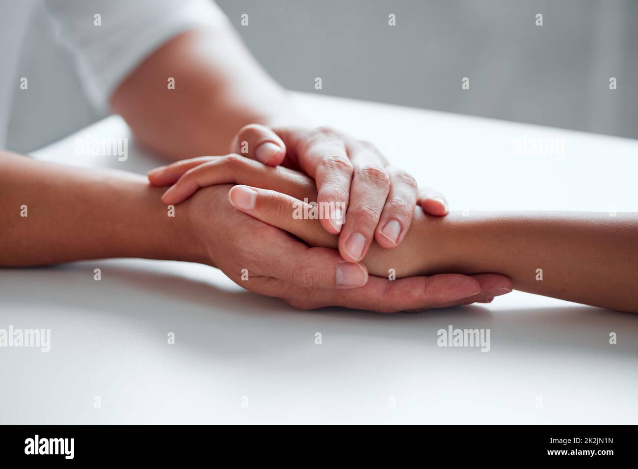 Freundlichkeit kann Leben verändern. Nahaufnahme von zwei nicht erkennbaren Personen, die sich die Hände hielten. Stockfoto