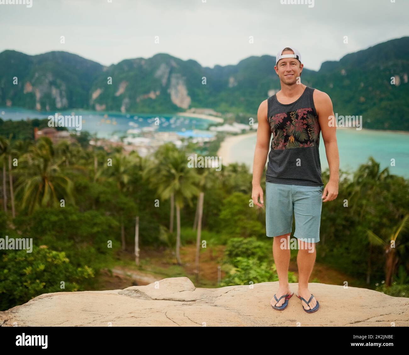 Lass uns tropisch werden. Porträt eines glücklichen jungen Mannes, der vor einer Insellandschaft posiert. Stockfoto