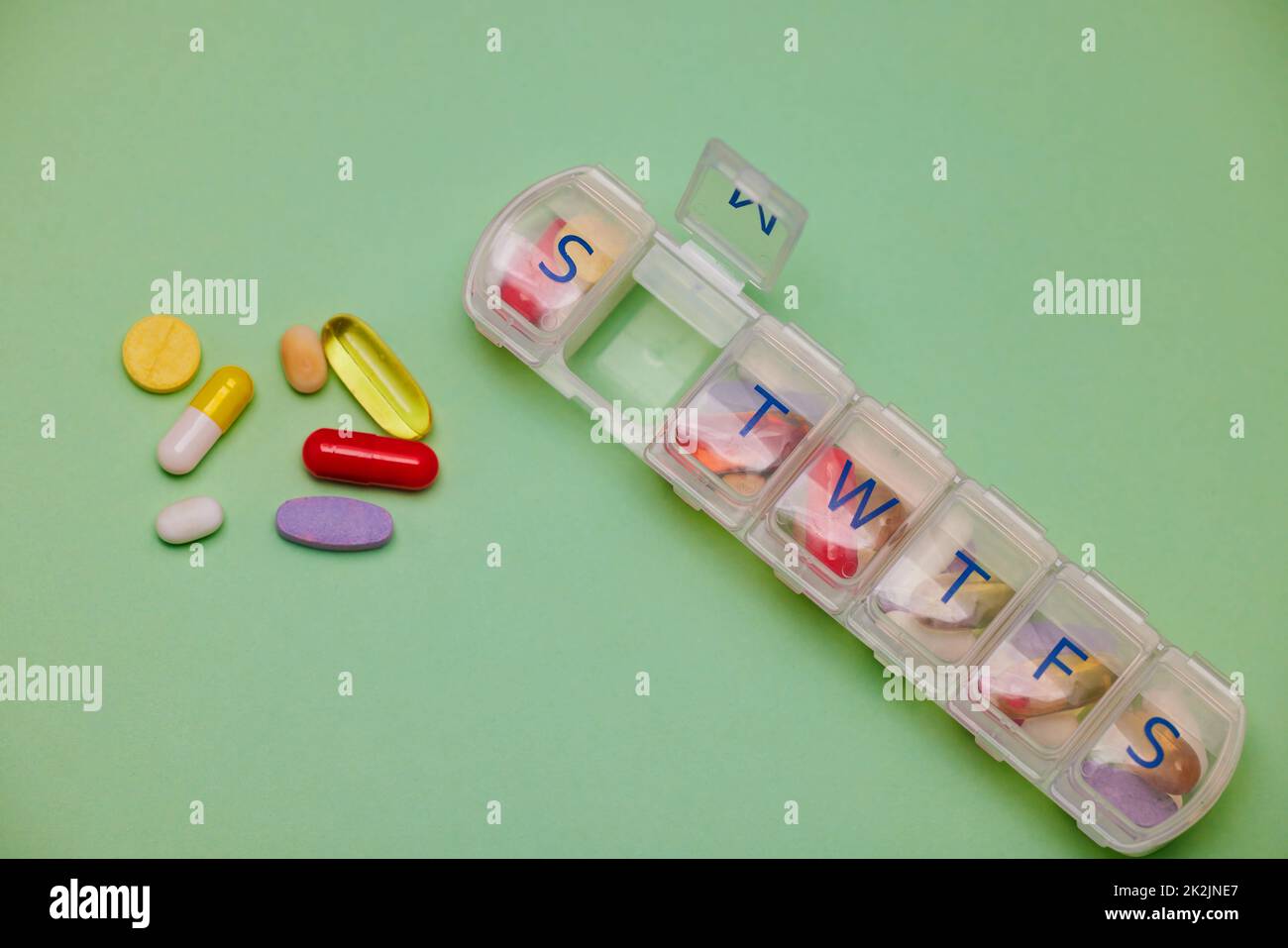 Eine Pille für jeden Bedarf. Aufnahme von medizinischen Geräten vor grünem Hintergrund. Stockfoto