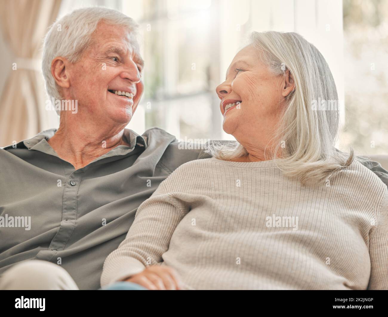 Wir haben noch so viel zu lachen. Aufnahme eines älteren Ehepaares, das sich zu Hause entspannt. Stockfoto