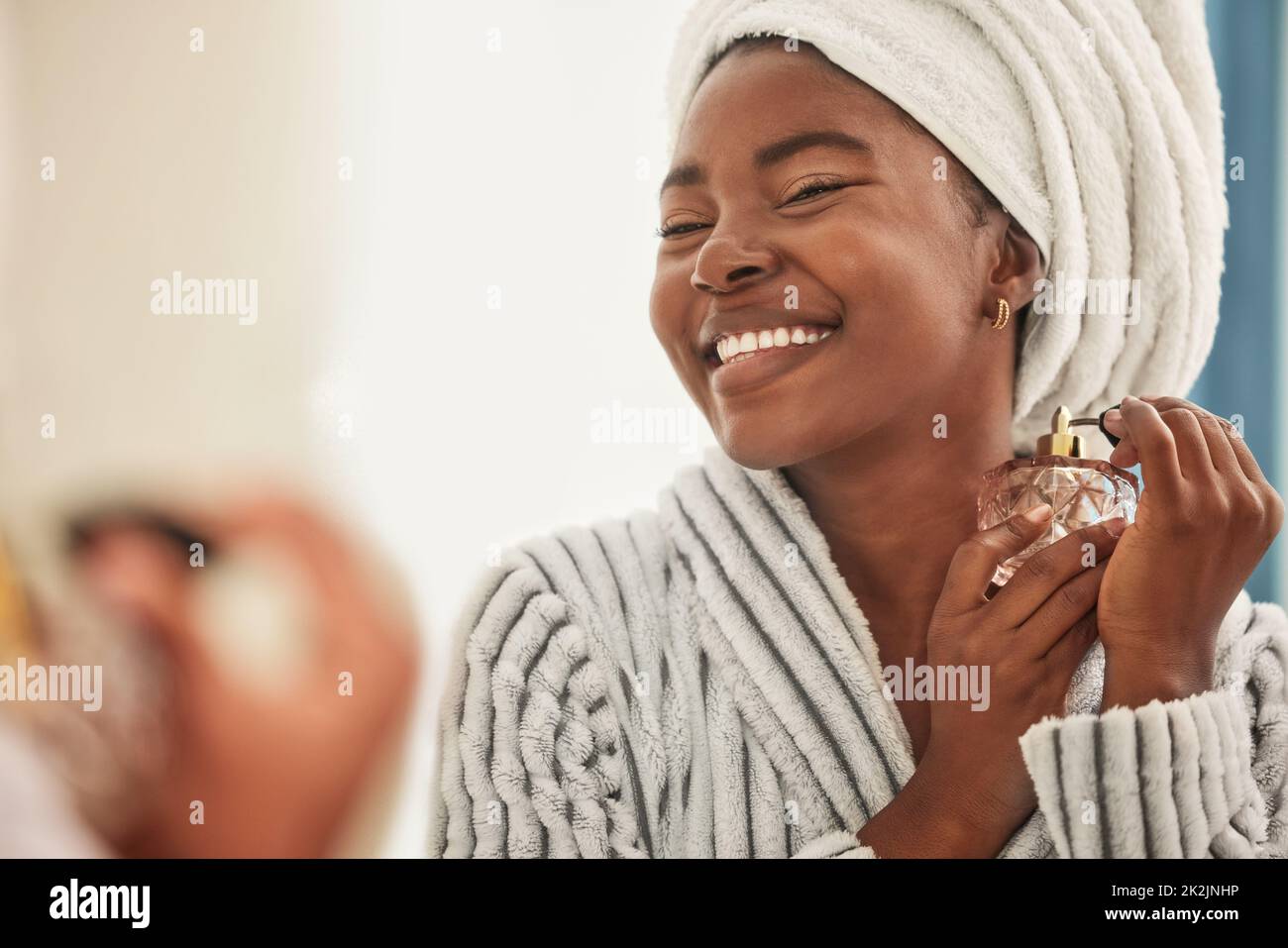 Dies ist mein Lieblingsduft. Aufnahme einer jungen Frau, die beim Gebrauch von Parfüm fröhlich aussieht. Stockfoto