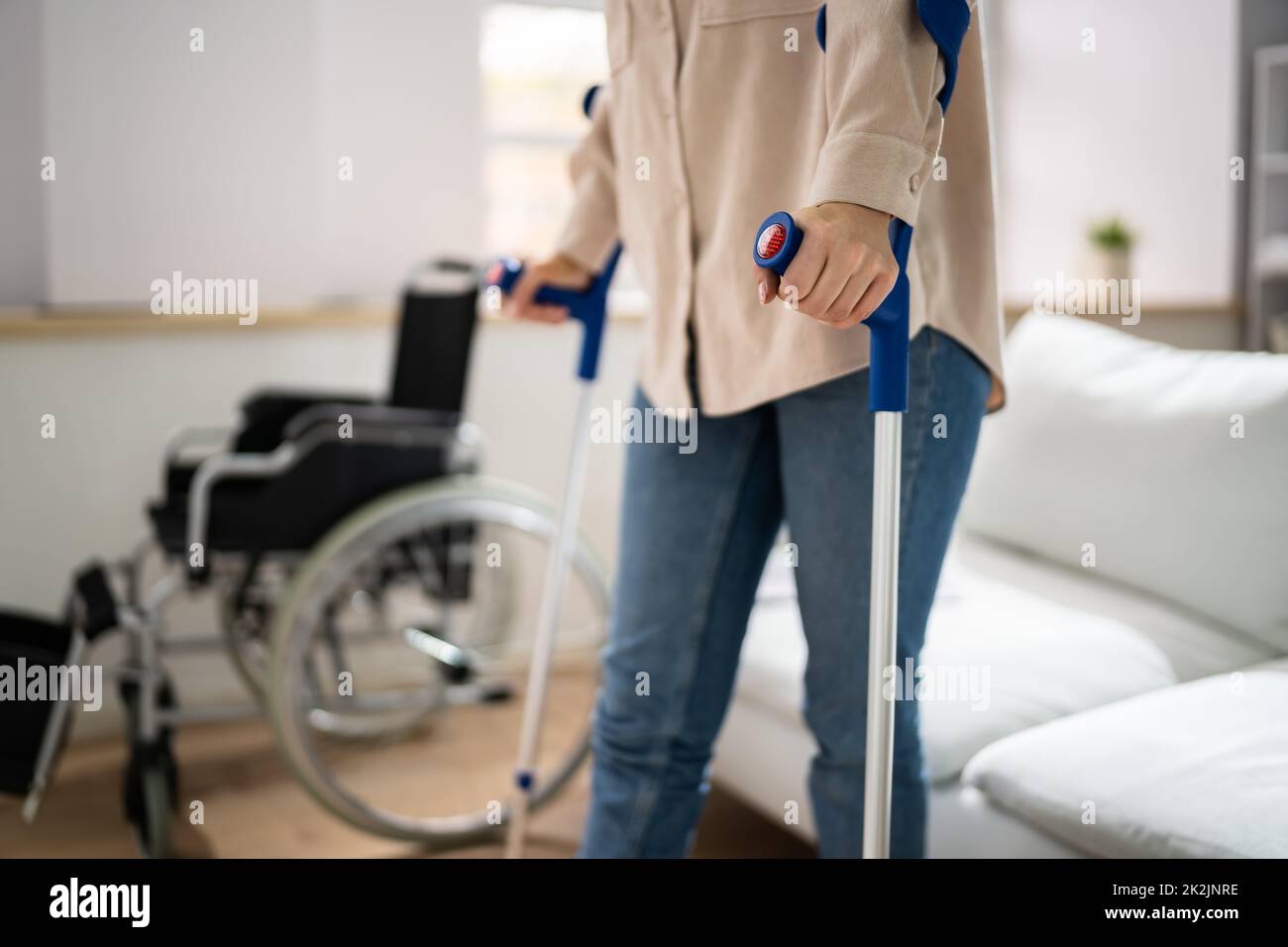 Bein Mit Krücken In Der Nähe Des Rollstuhls Verletzen Stockfoto