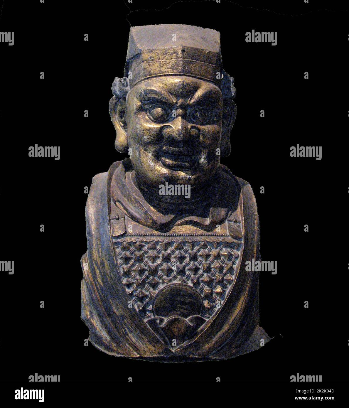 Vergoldeter Bronzekopf einer buddhistischen Schutzfigur. Yuan-Dynastie / 14.. Jahrhundert n. Chr. An den Eingängen zu den buddhistischen Tempeln wurden in Schutzfunktion heftige gepanzerte Schutzfiguren aufgestellt. Stockfoto