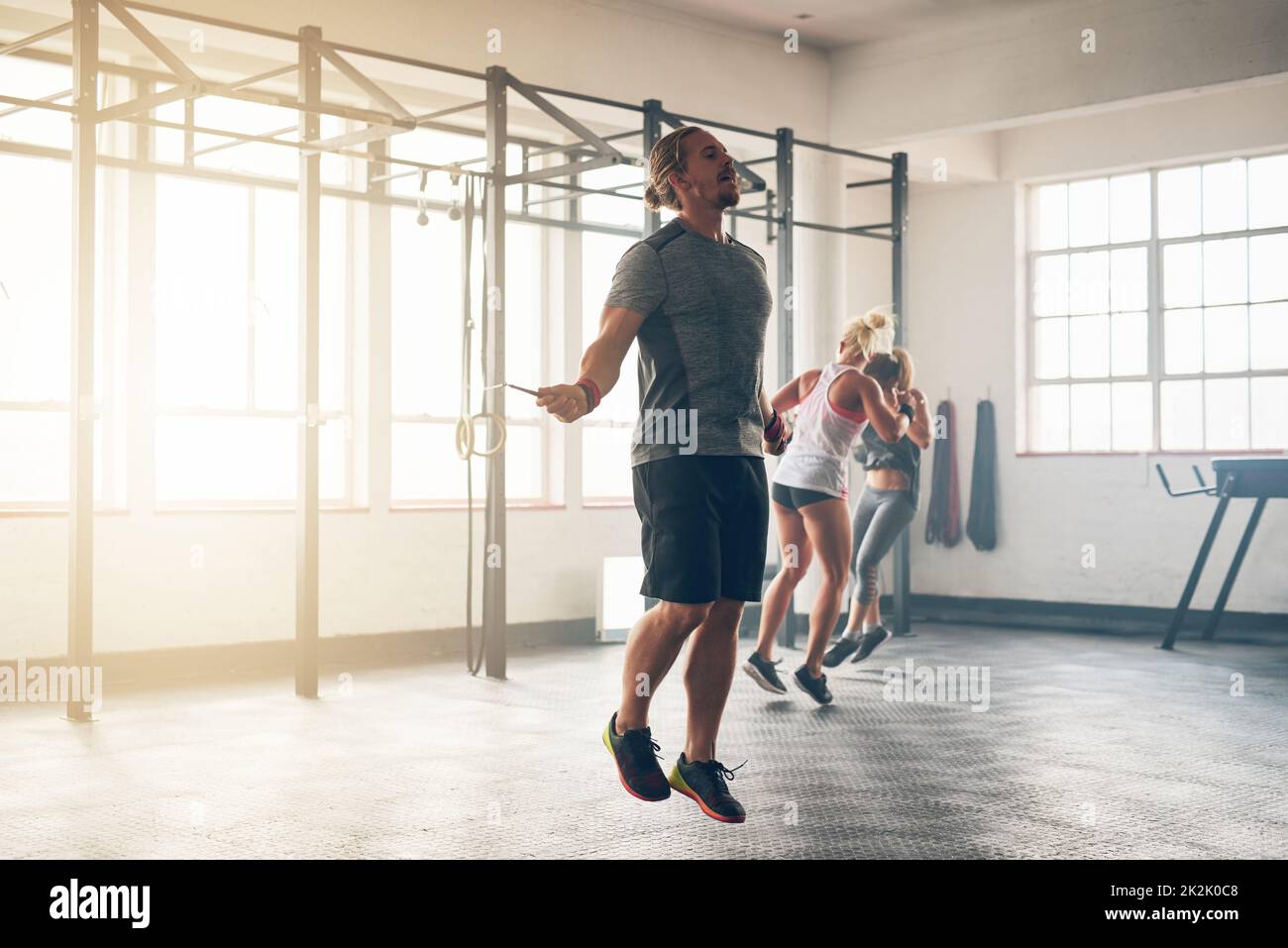 Vervollkommnen seiner Form. Aufnahme eines muskulösen jungen Mannes, der im Fitnessstudio mit einem Springseil trainiert. Stockfoto