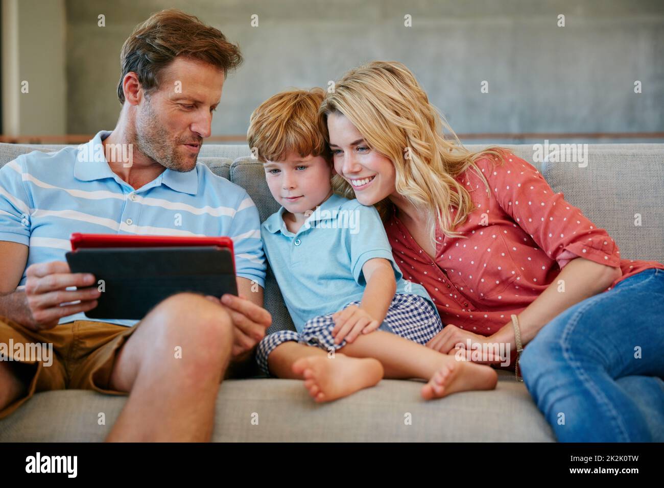 Es gibt immer etwas unterhaltsames online zu sehen. Eine Aufnahme einer Familie, die ein digitales Tablet zu Hause verwendet. Stockfoto