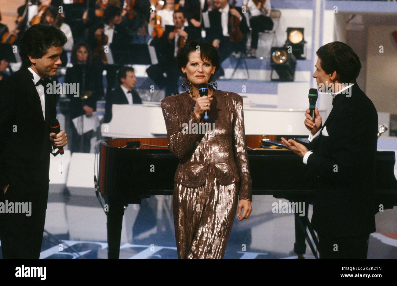 Telethon 1990 Charity-Abend. Die Sponsorin des Abends, die Schauspielerin Claudia Cardinale, und die Moderatoren Claude Sérillon (l.) und Gérard Holtz (r.). 8. Dezember 1990 Stockfoto