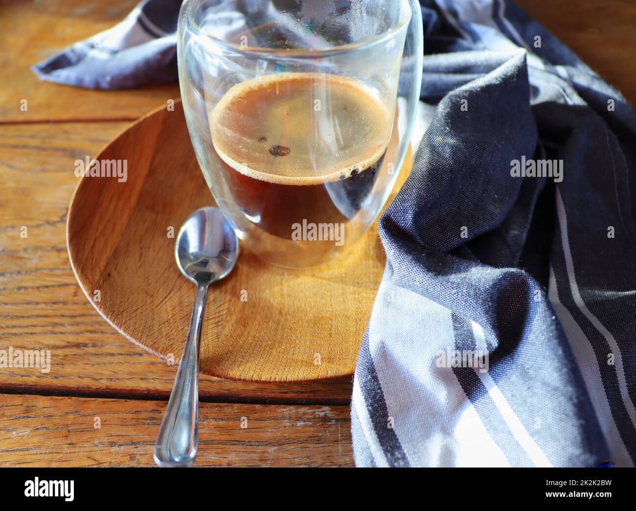 Transparenter doppelwandiger Glaskrug mit Espresso-Kaffee auf rustikalem Holzhintergrund Stockfoto