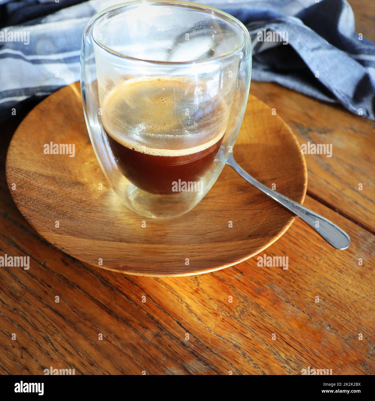 Transparenter doppelwandiger Glaskrug mit Espresso-Kaffee auf rustikalem Holzhintergrund Stockfoto