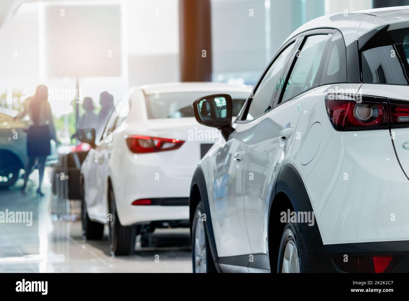 Weißer SUV mit Blick nach hinten in einem modernen Luxusausstellungsraum für Verkäufer und Kunden. Bürokonzept Autohaus. Händlergeschäft. Leasing-Service für Kraftfahrzeuge. Händlerfirma. Neuwagenkauf. Stockfoto