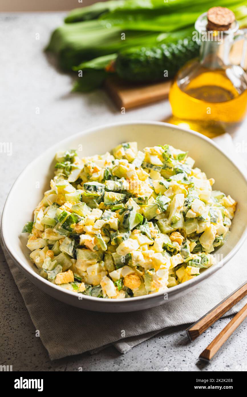 Gesunder Salat aus grünem Lauch, pochiertem Ei und Gurke, Nahaufnahme ...