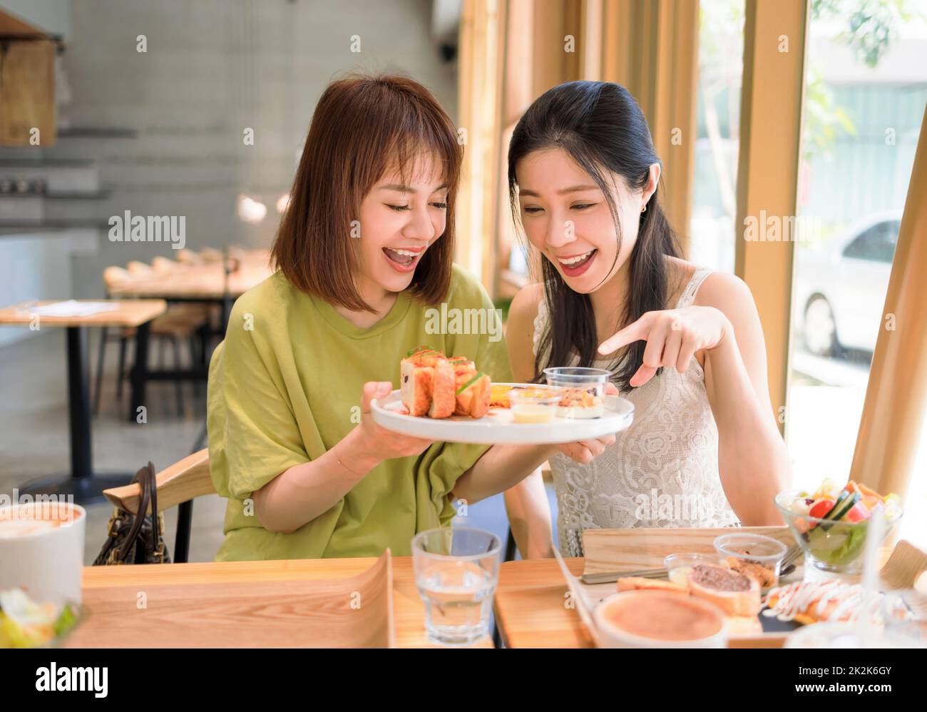 Glückliche Freundinnen, die gemeinsam im Restaurant zu Mittag essen Stockfoto