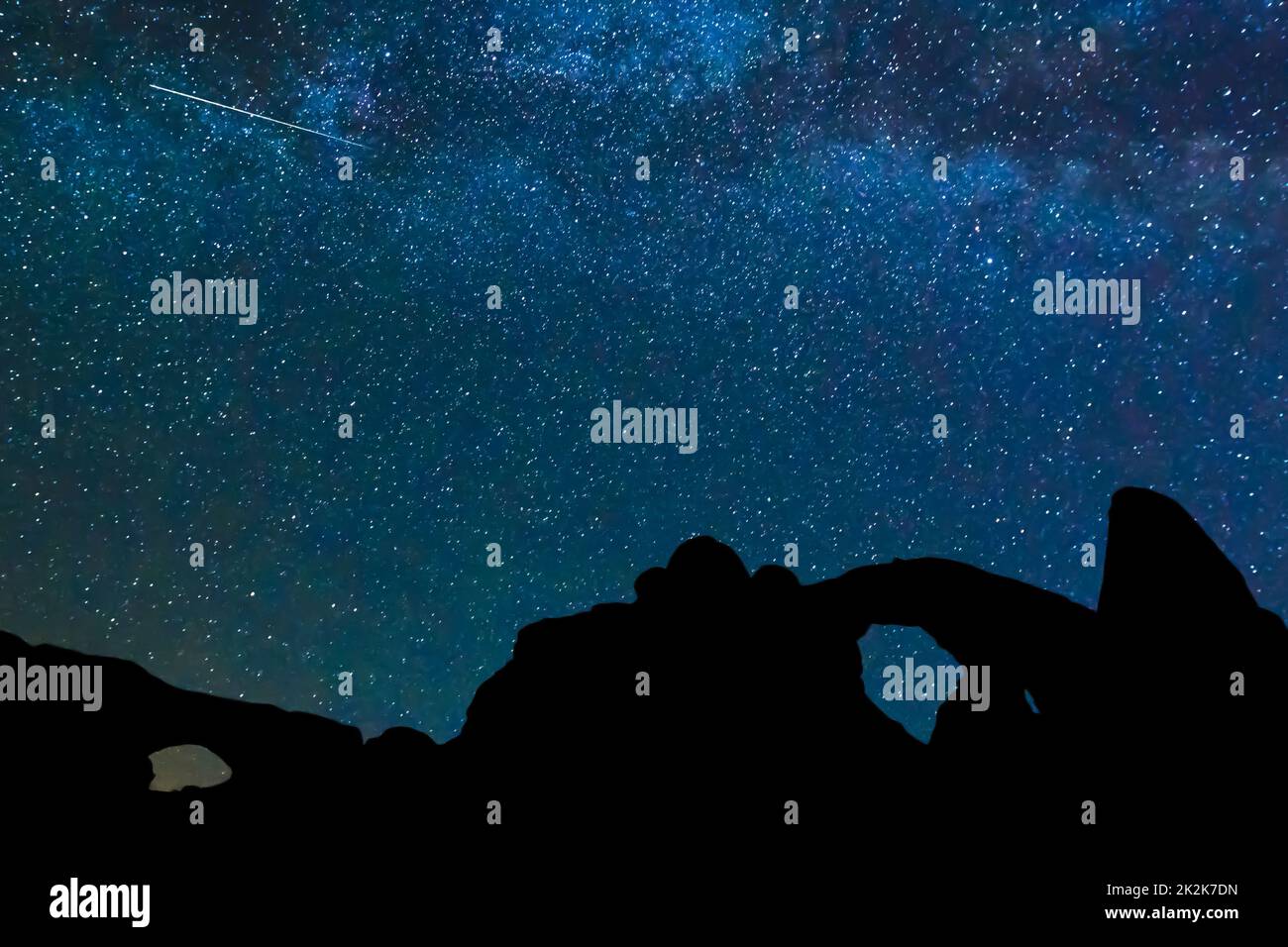 Die Milchstraße und ein Meteorit über Turret Arch und dem Nordfenster im Arches National Park, Moab, Utah, USA. Die Bögen sind in Silhouette. Stockfoto