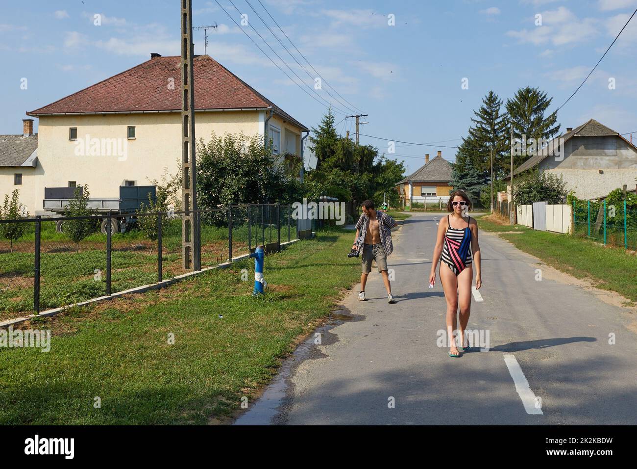 Festivalbesucher gehen auf der nahe gelegenen Dorfstraße Stockfoto