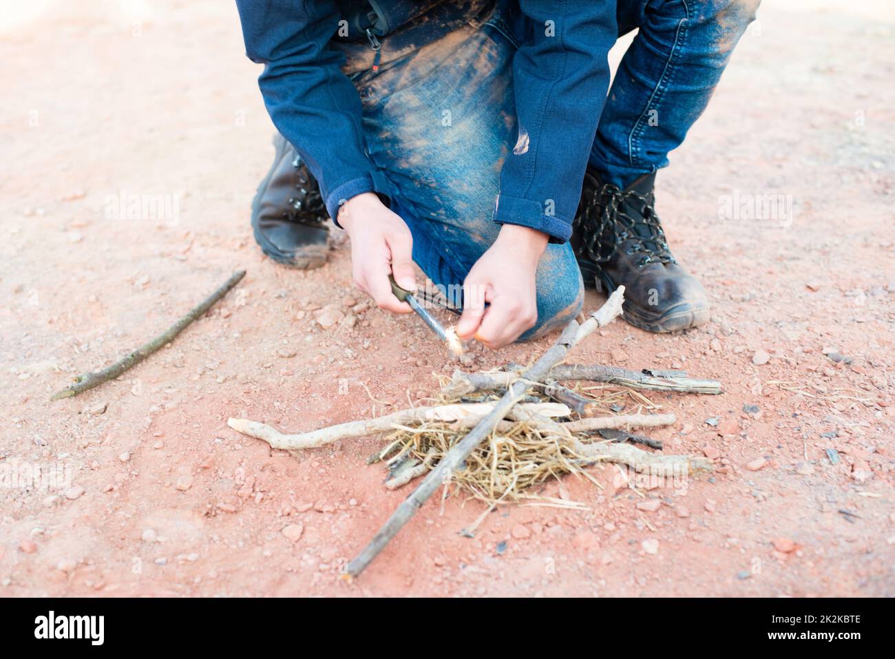 Ein Feuer mit einem Feuerstahl, Überlebens- und Abenteuerausrüstung, Outdoor-Fähigkeiten, Mann, der ein Lagerfeuer macht Stockfoto